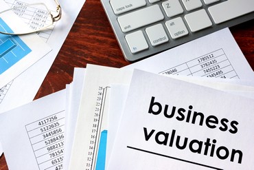 Business valuation written in a document and business charts.